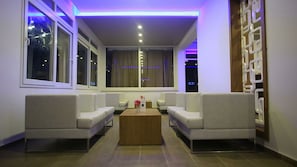 A modern living room with a sofa set, a coffee table, and large windows.