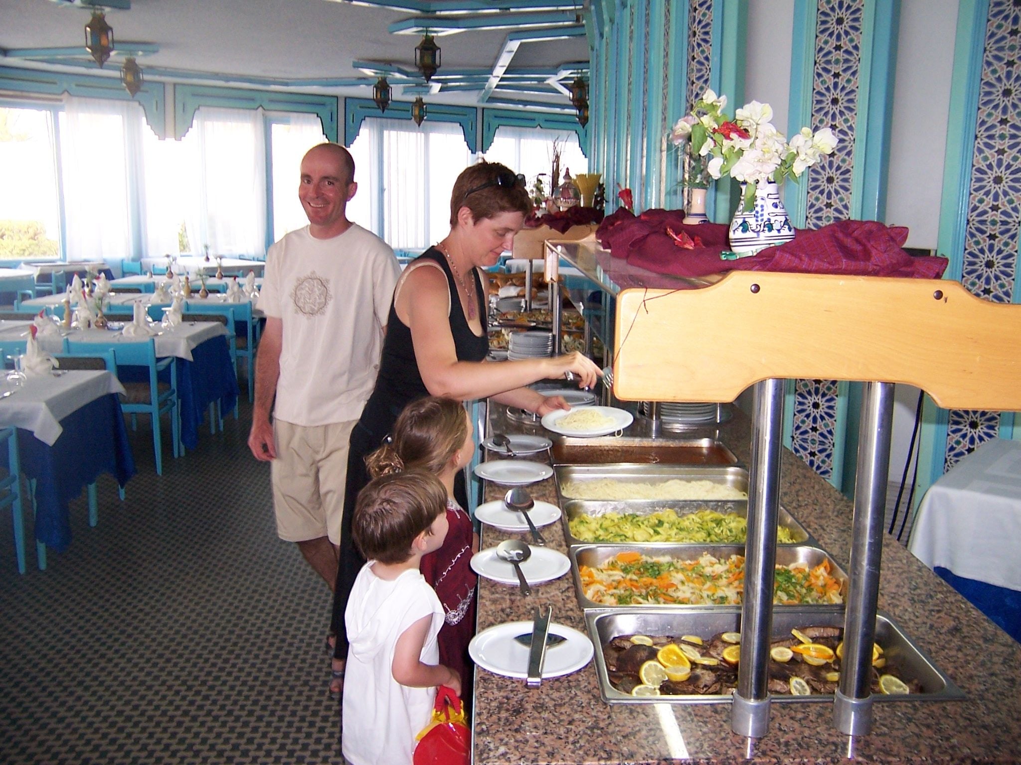 A buffet setup with multiple food stations and a person serving food.