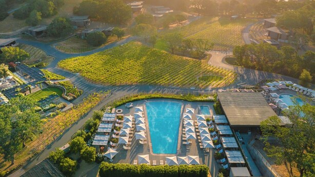 An aerial view of a resort with a large swimming pool surrounded by sun loungers and a vineyard. - Montage Healdsburg (Healdsburg)