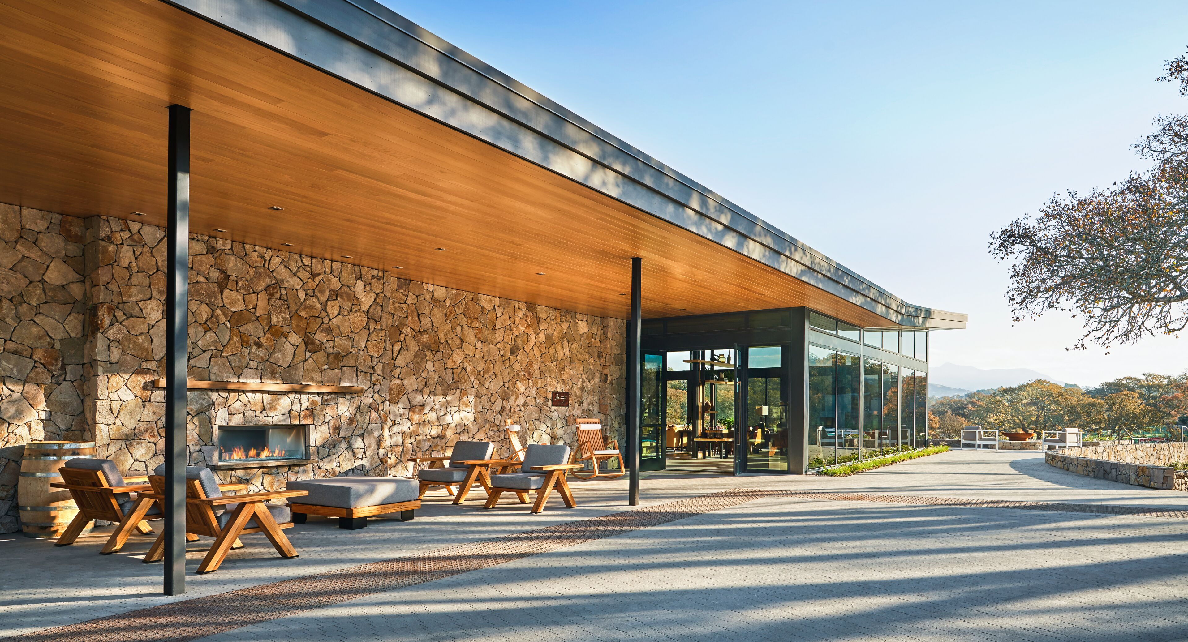 Un espace extérieur moderne, aménagé avec des murs en pierre et des meubles en bois.