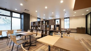 A modern library with wooden tables and chairs, bookshelves, and large windows. - R&B Hotel Nagoya-Ekimae (Nagoya)