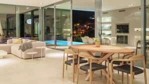 A modern living room with a pool, large windows, and a dining area. - NATURE VILLA BONAIRE - Exclusive villa with infinity pool. (Alcúdia)