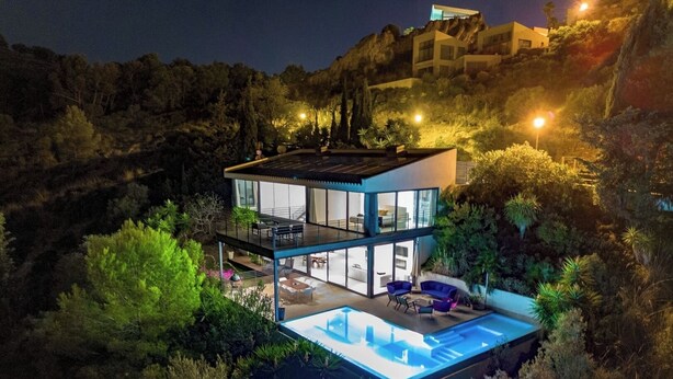 A modern two-story house with a glass facade, a swimming pool, and a balcony. - NATURE VILLA BONAIRE - Exclusive villa with infinity pool. (Alcúdia)