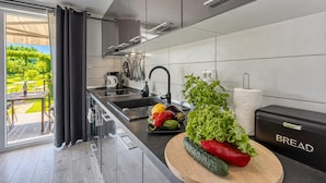 Eine moderne Küche mit großem Fenster, einer Spüle und einer Arbeitsplatte mit frischem Gemüse.