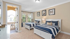 A bedroom with two beds, a glass desk, and a balcony. - 5-bedroom ALL SUITES PET FRIENDLY Luxury home Minutes to DISNEY & THEME PARKS (Reunion)