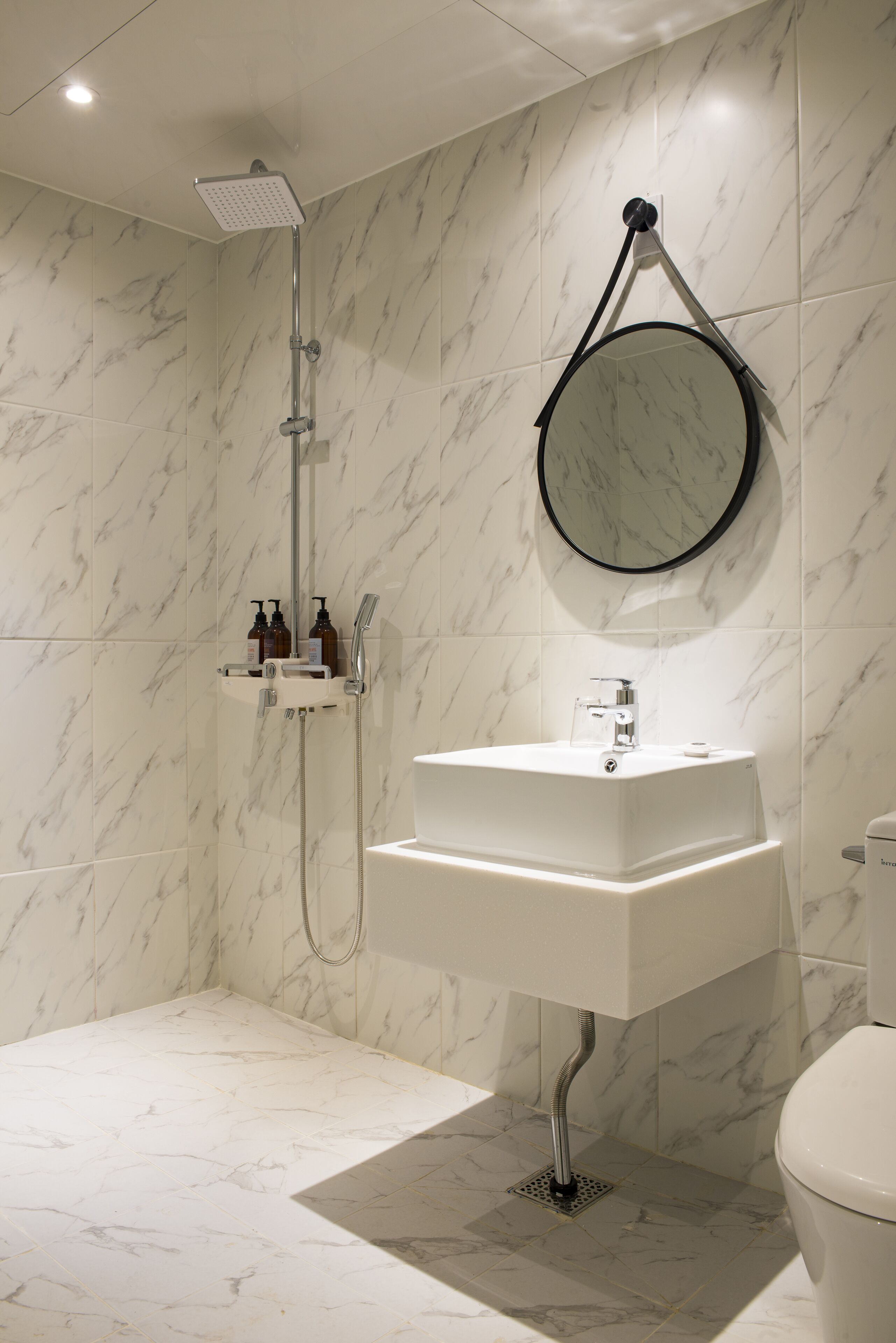 Un baño con ducha, lavamanos e inodoro.