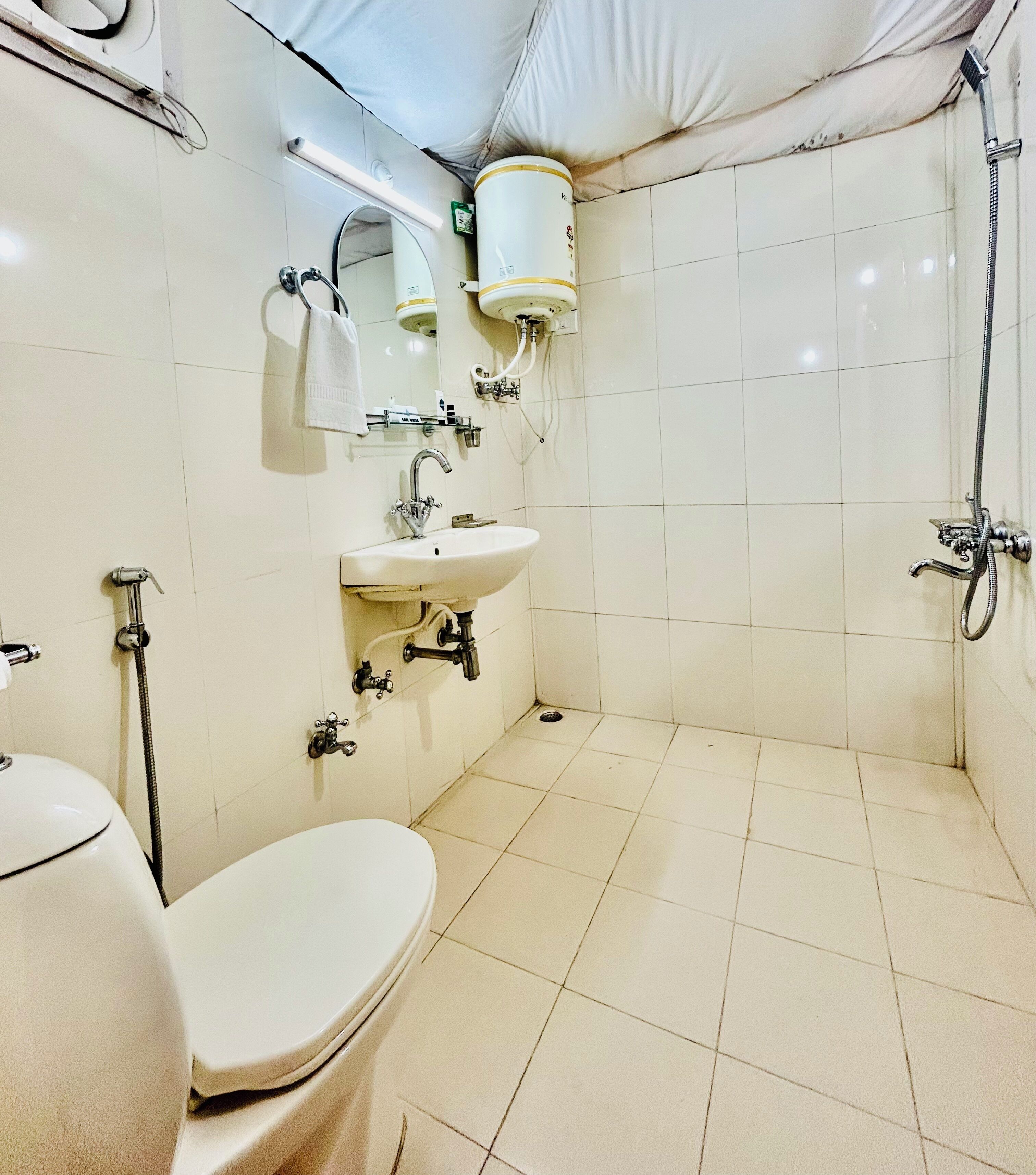 A bathroom with a toilet, sink, and shower.