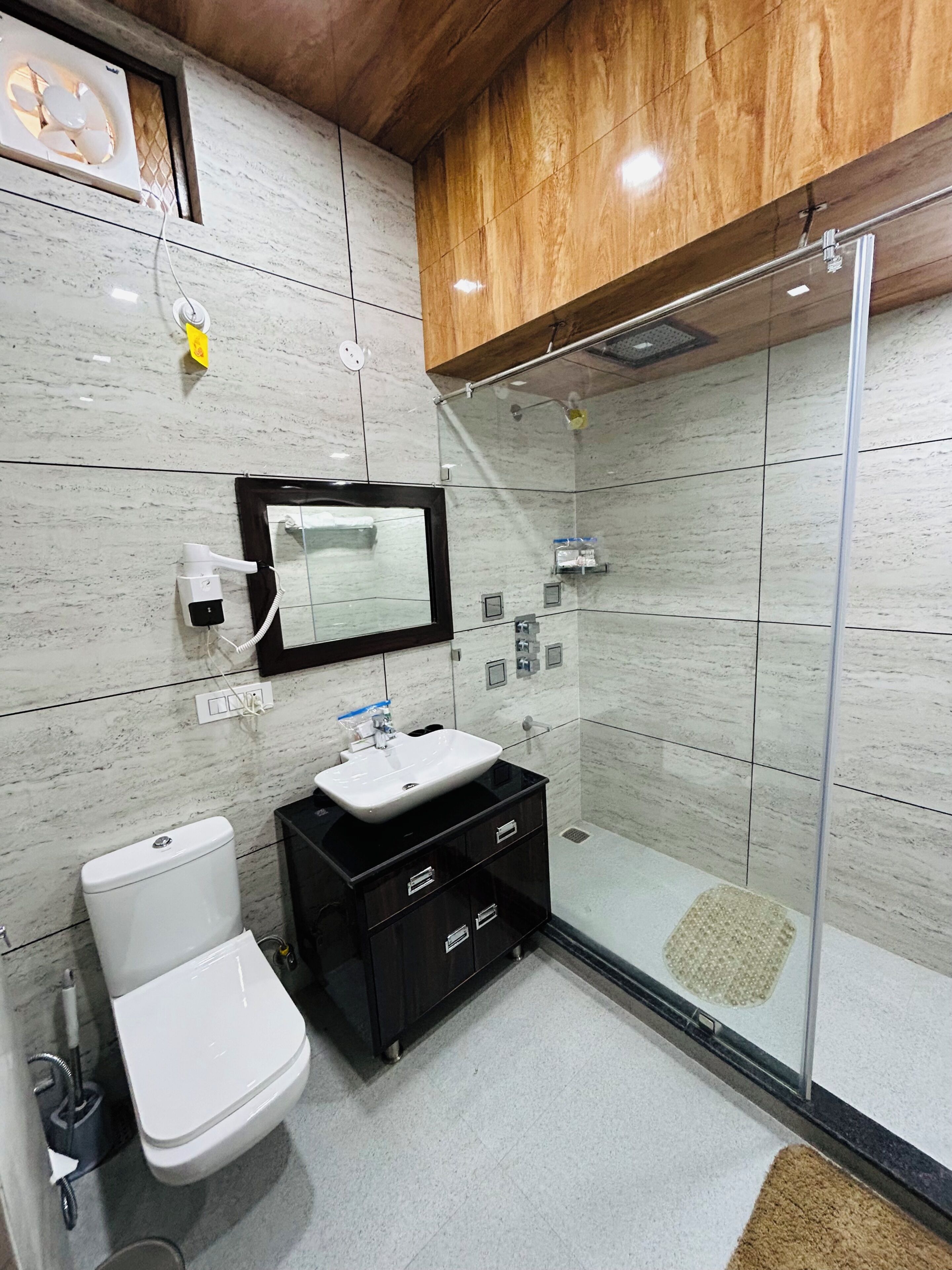 Un baño moderno con inodoro, lavamanos y ducha.