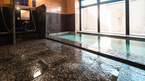 A swimming pool with a tiled floor and walls, a shower area with a marble wall, and a window providing natural light. - Business Hotel Hane Ise Inter (Ise)