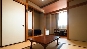 A traditional Japanese room with tatami flooring, a wooden table, a television, and a sliding door. - Business Hotel Hane Ise Inter (Ise)