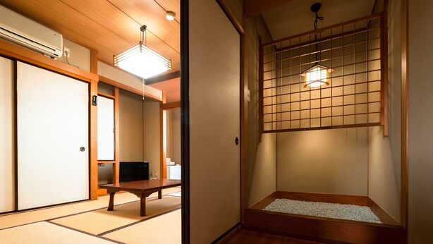 A traditional Japanese room with tatami flooring, a sliding door, a low table, and a shoji screen. - Business Hotel Hane Ise Inter (Ise)