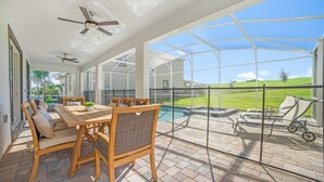 A covered patio with a pool, outdoor furniture, and a clear view of the surrounding landscape.