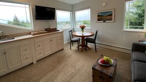 A modern kitchen with a dining area, large windows, and a flat-screen TV. - Gracie's Homer House; Home With A View (Homer)