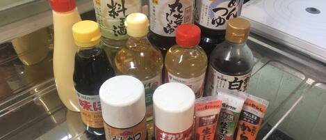 A variety of condiment bottles on a glass counter.