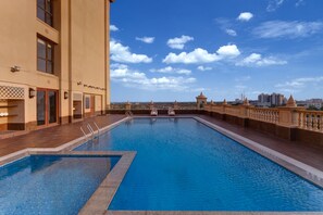 A rooftop swimming pool with a clear view of the city skyline.