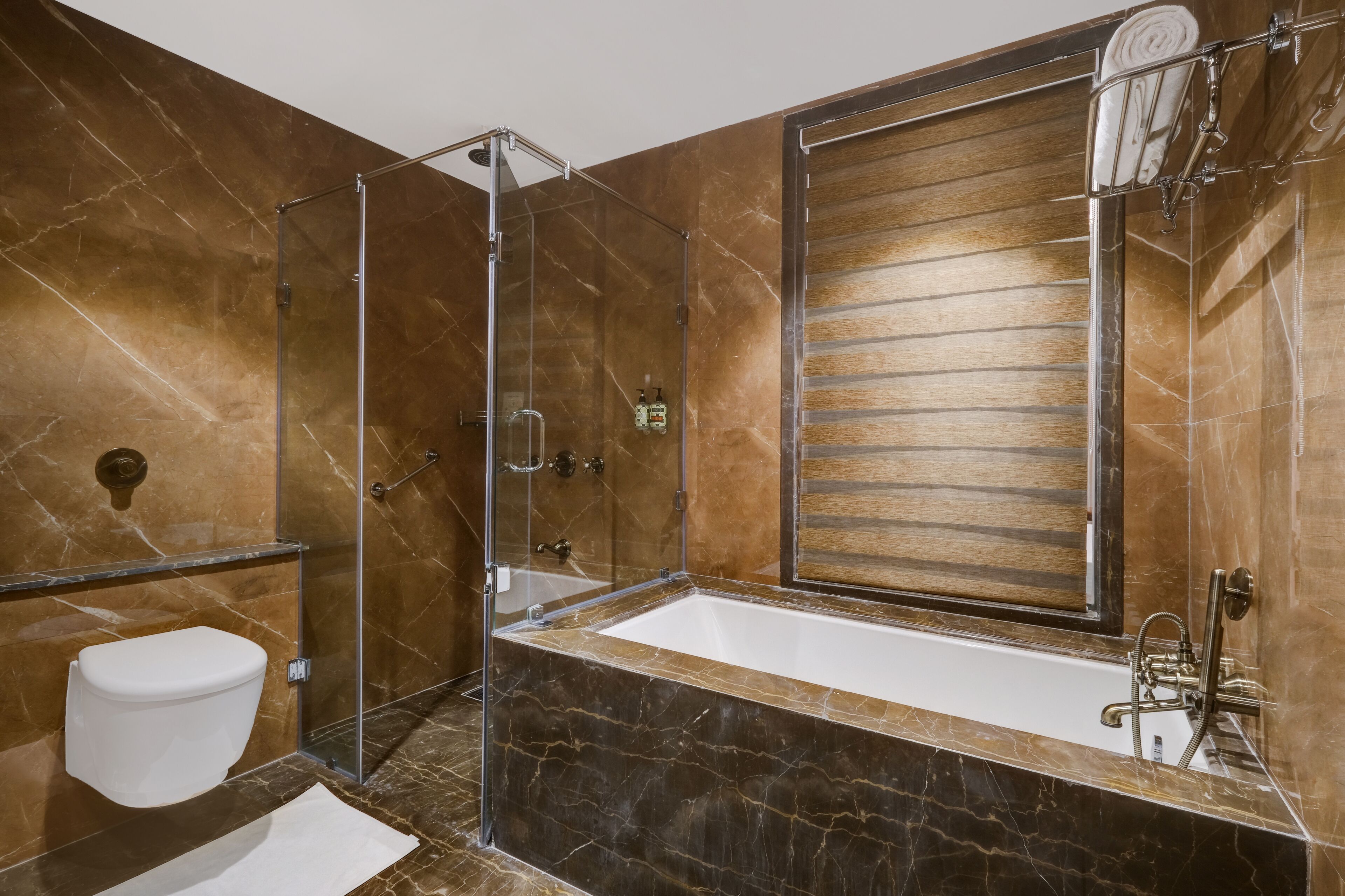 A modern bathroom with a glass-enclosed shower, a large bathtub, and a wooden vanity.