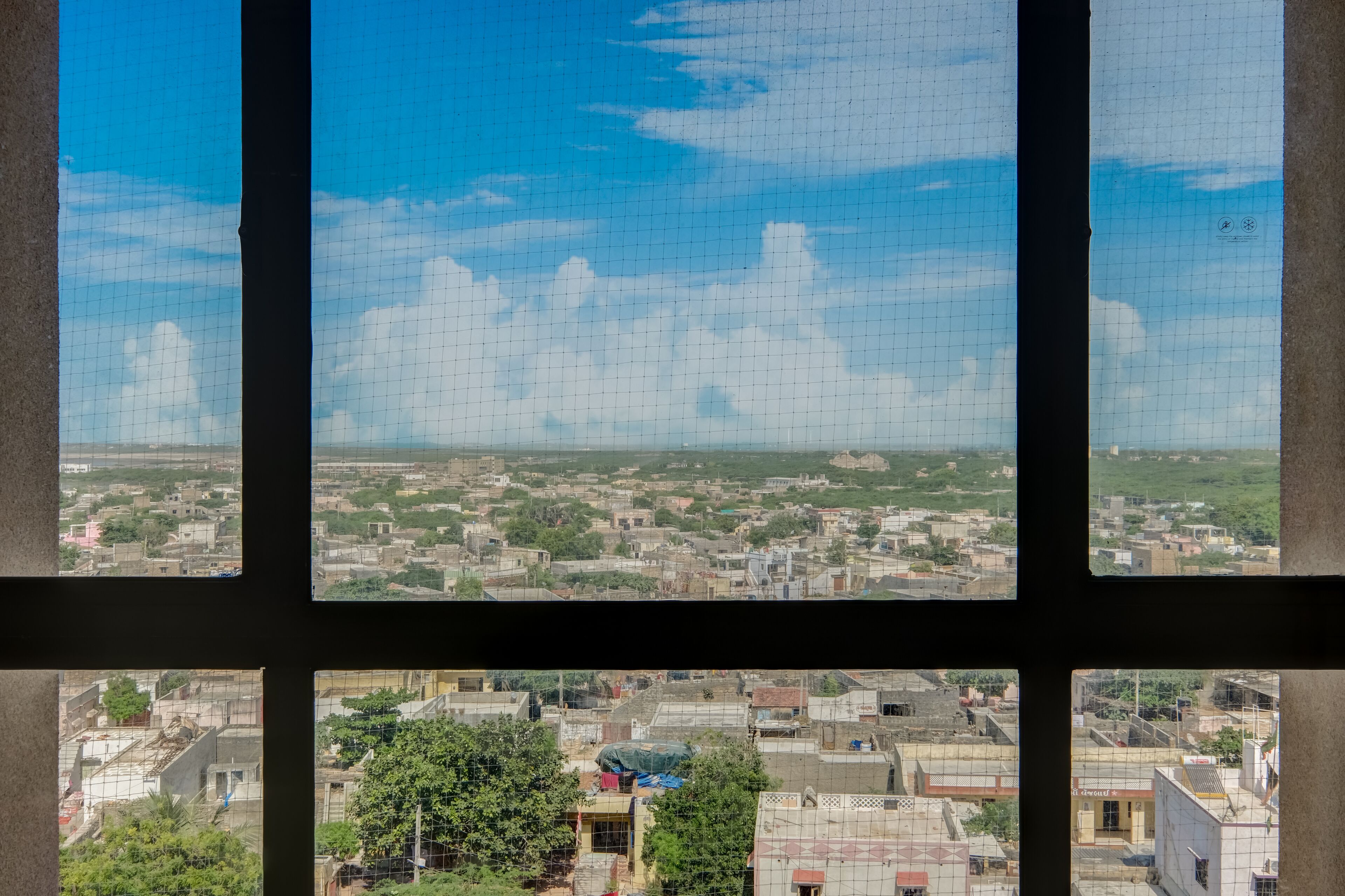 A cityscape through a window with a grid pattern.