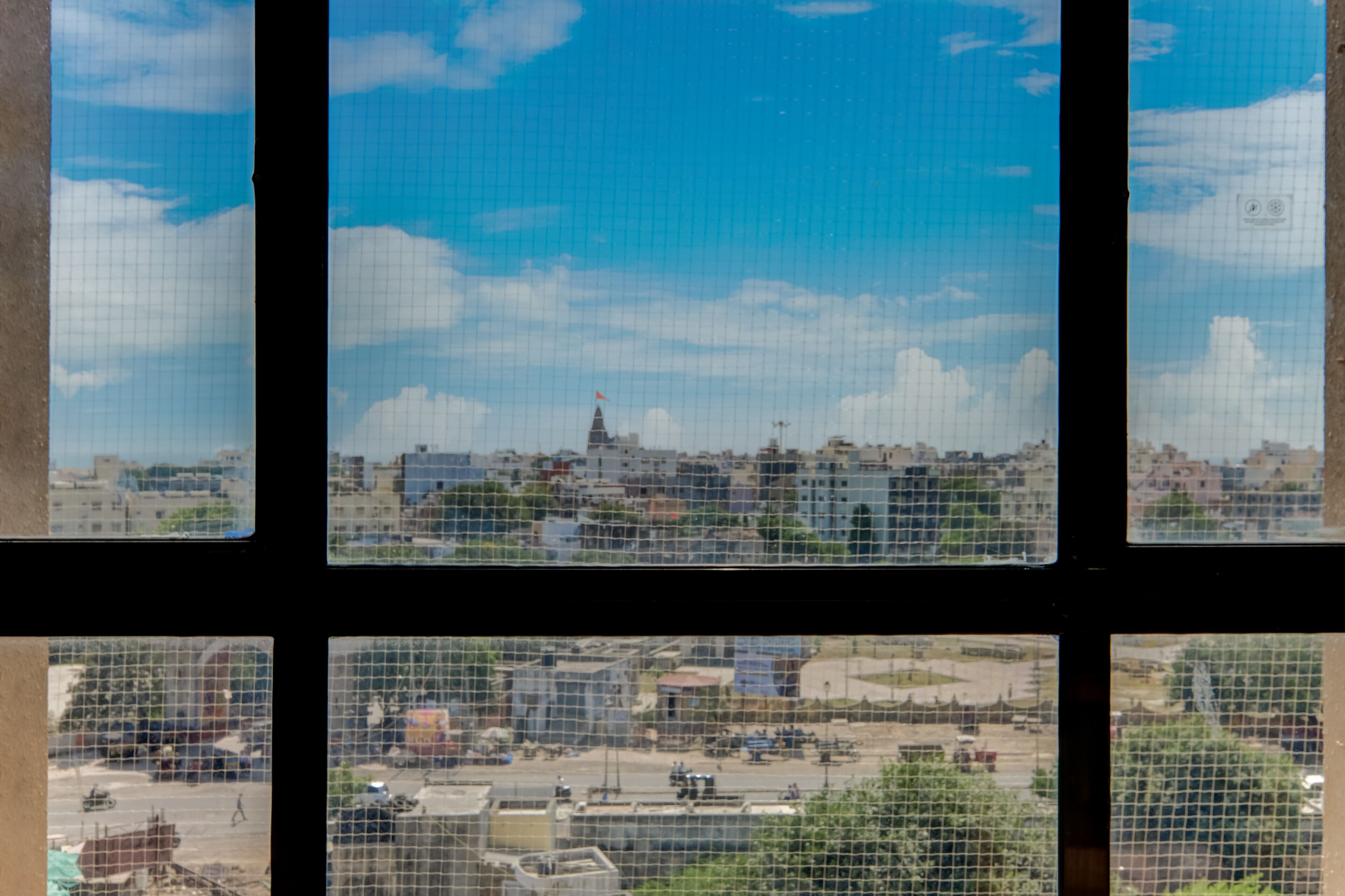 A cityscape through a window with a grid pattern.