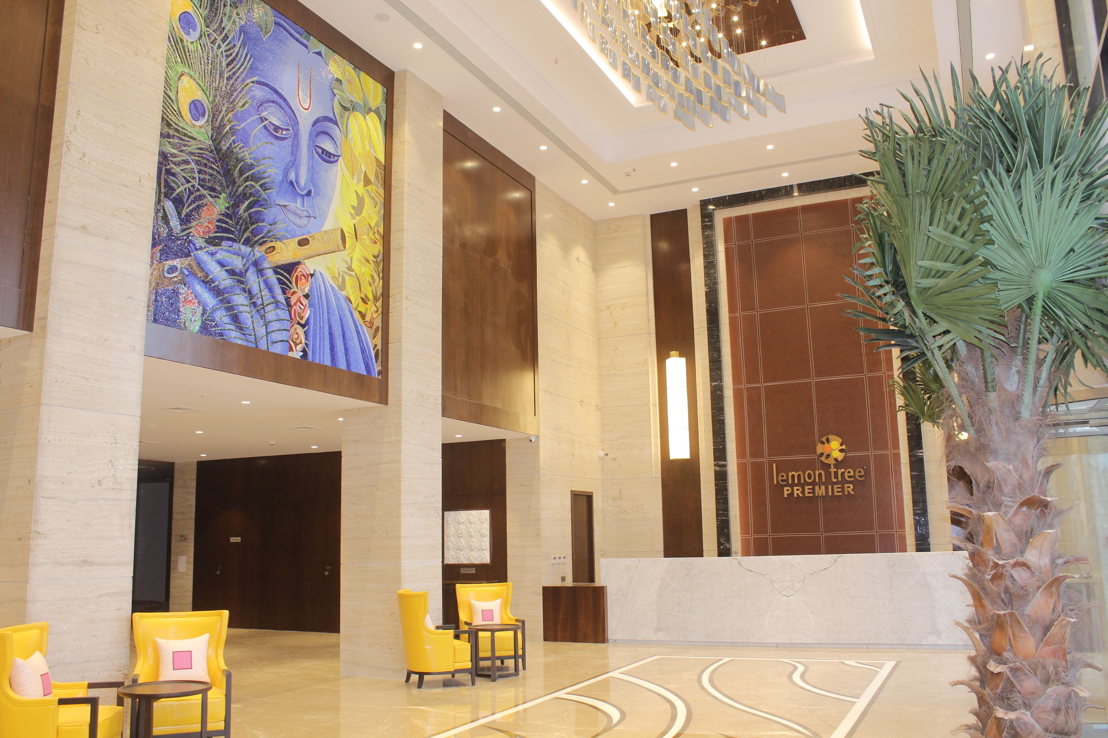 A hotel lobby with a large mural, a reception desk, and seating area.