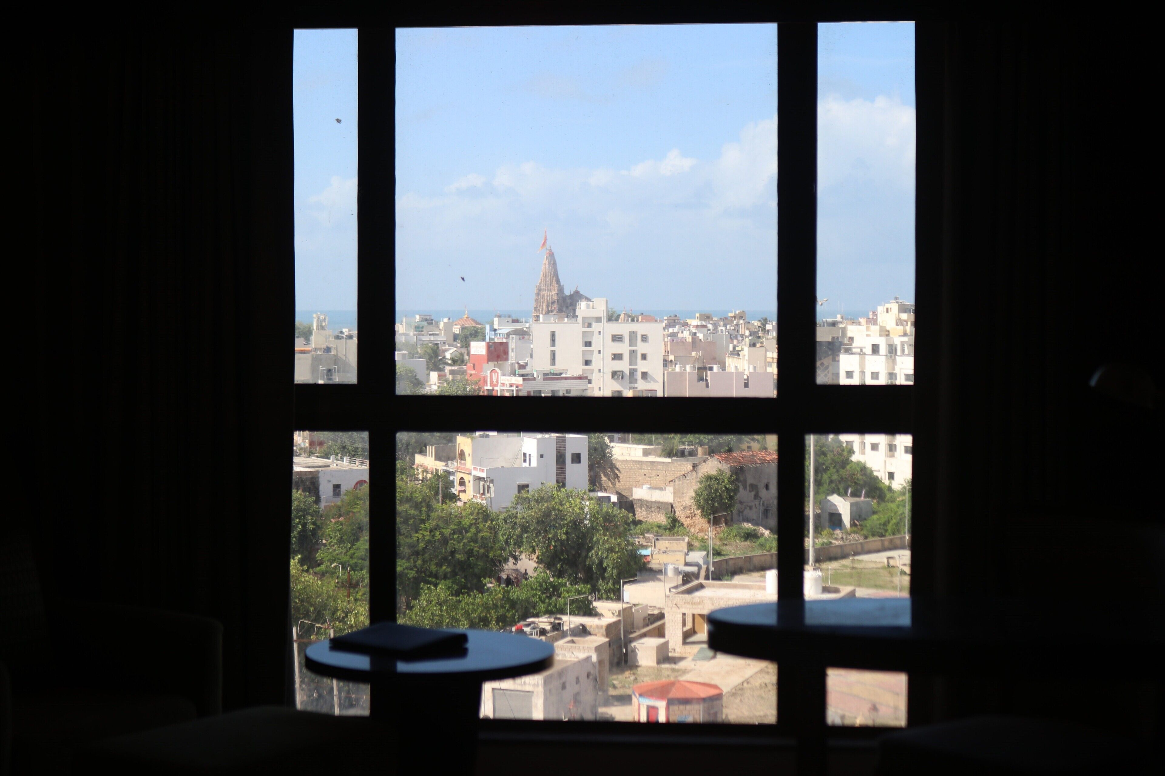 A view from a window with a view of a cityscape, including buildings and a prominent tower.
