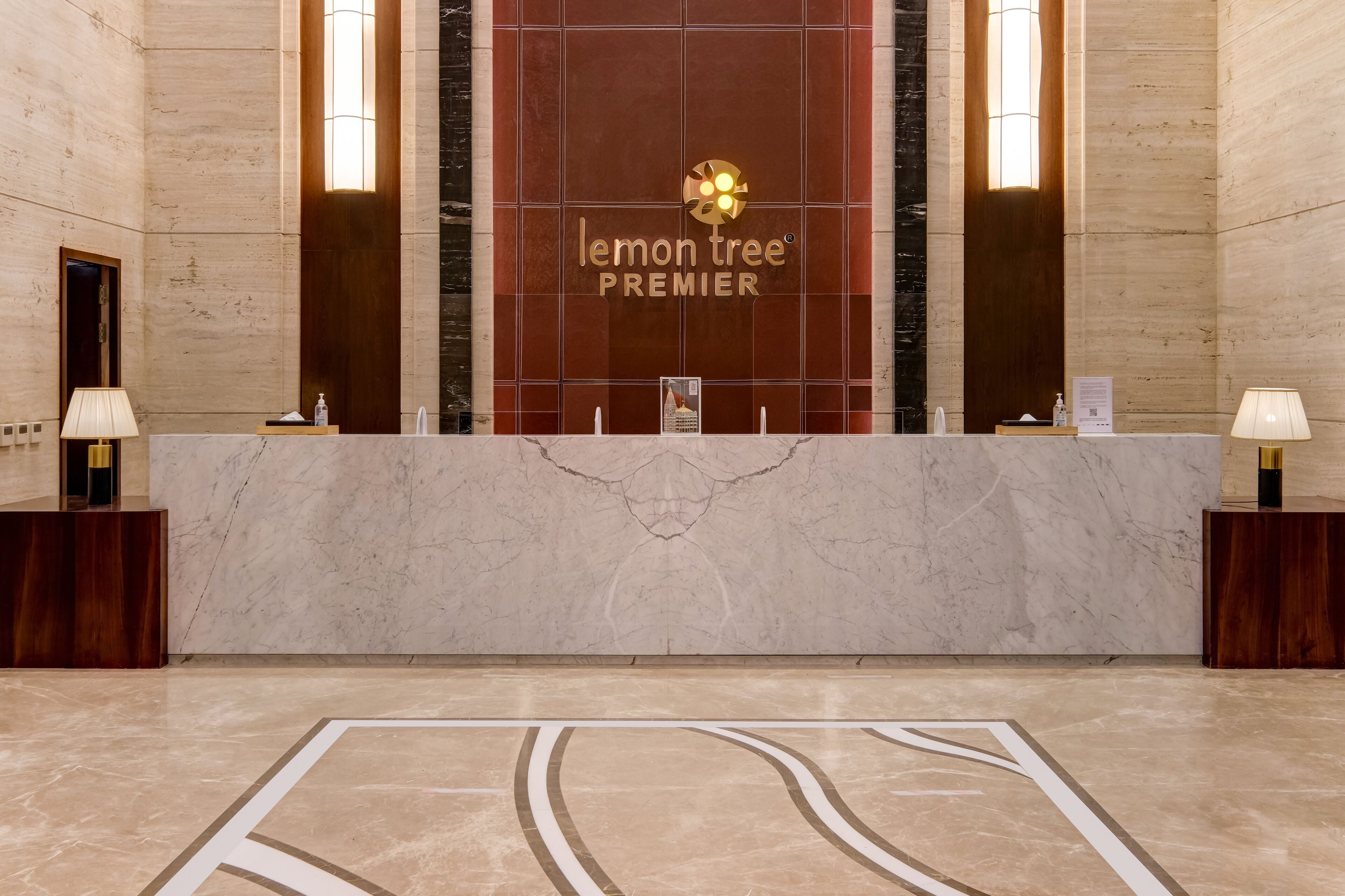 A reception desk with a marble top and a logo that reads "lemon tree PREMIER".
