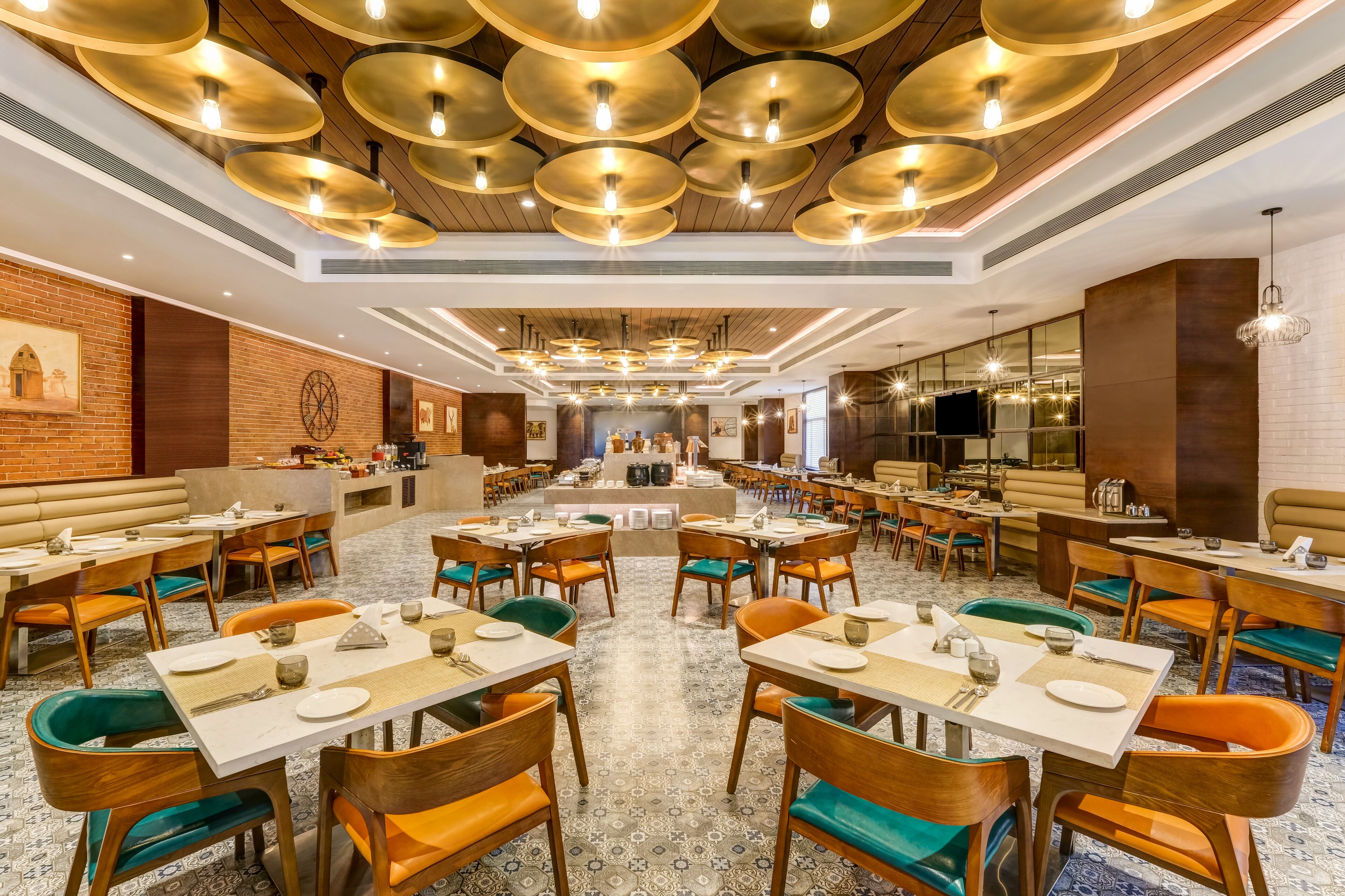 Un vaste espace dédié à la salle à manger, avec de nombreuses tables et chaises, un bar central et un sol à motifs.