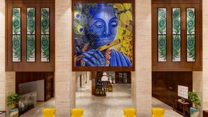 A lobby with a large mural, seating, and a reception area.