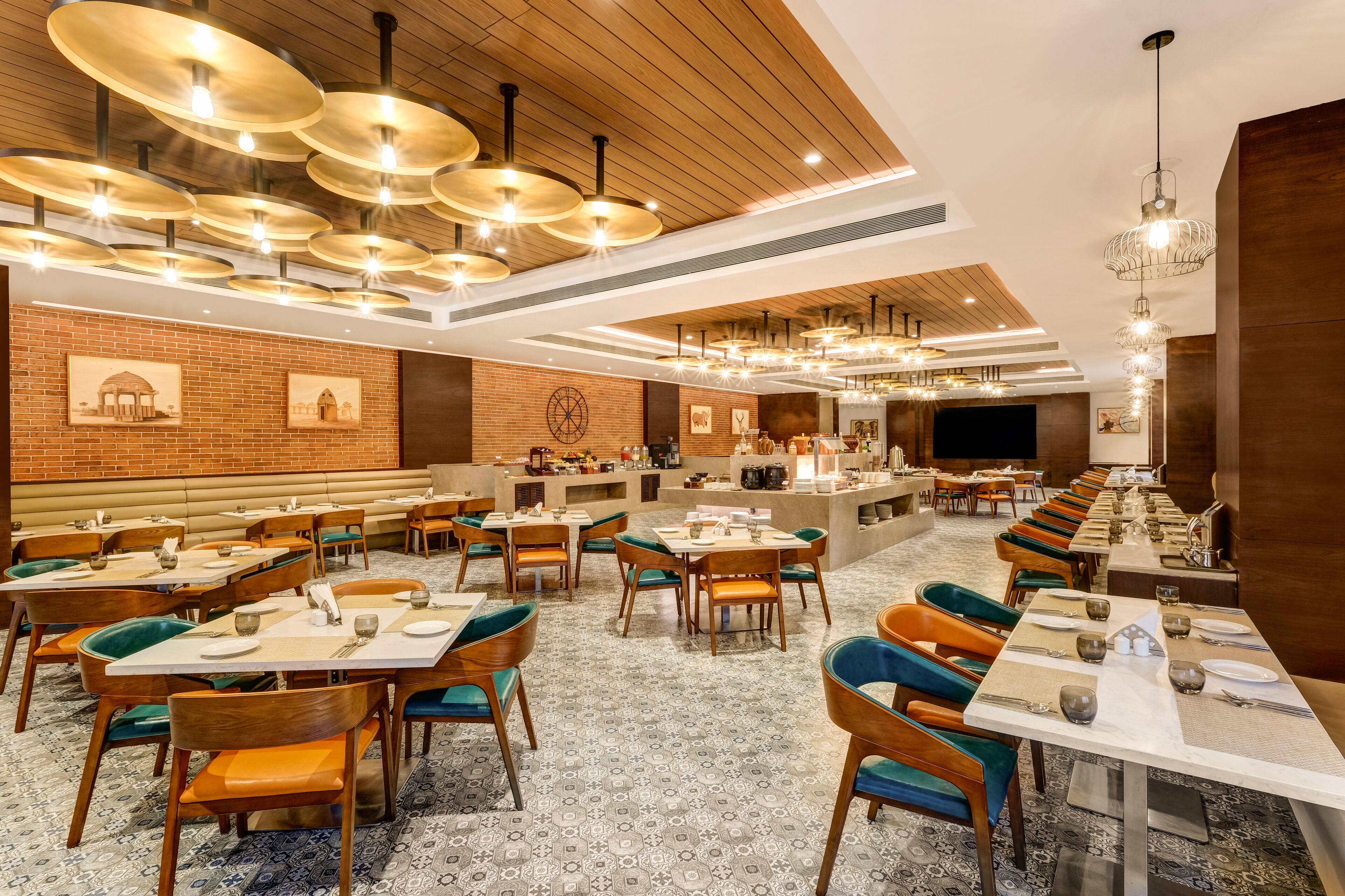 A spacious restaurant with multiple dining areas, wooden ceiling, and modern lighting fixtures.