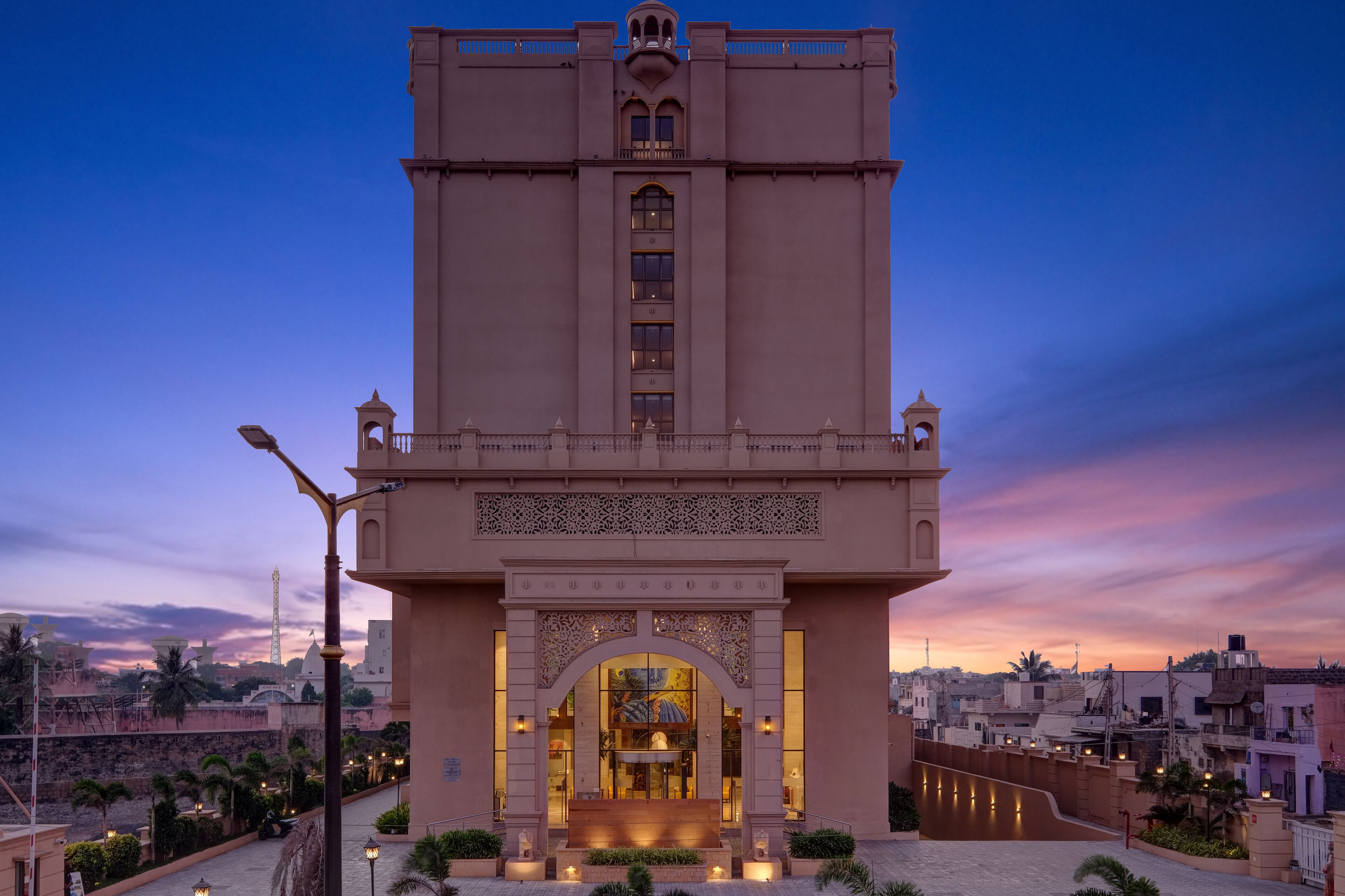 A large, beige building with a central archway and a tall tower.