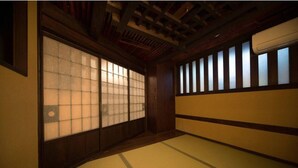 A traditional Japanese room with tatami flooring, shoji screens, and a wooden ceiling. - Hostel Ko-fu (Osaka)