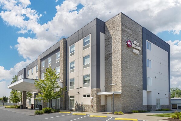 A multi-story hotel with a modern design, featuring a stone facade and a covered entrance area.