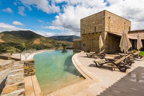 Una piscina al aire libre, tumbonas