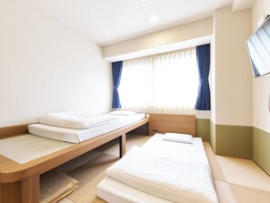 A hotel room with two single beds, a wooden bench, a small table, and a TV mounted on the wall. - Standard 22 people Twin nonsmoking Room only A / Kyoto Kyōto (Kyoto)