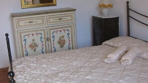 Un dormitorio con cama, cómoda, lámpara y espejo.