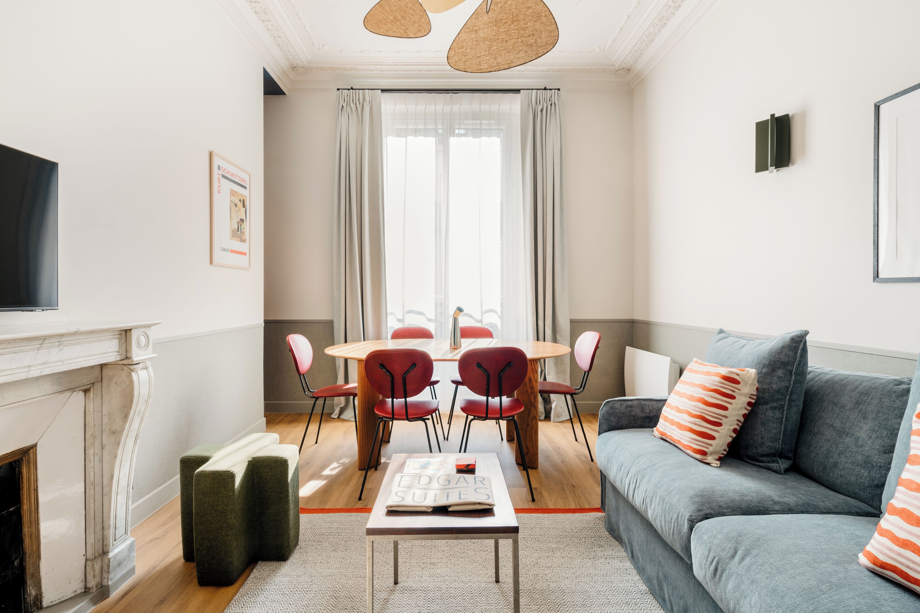 Una sala de estar moderna con chimenea, un sofá, una mesa de comedor con sillas y una televisión.
