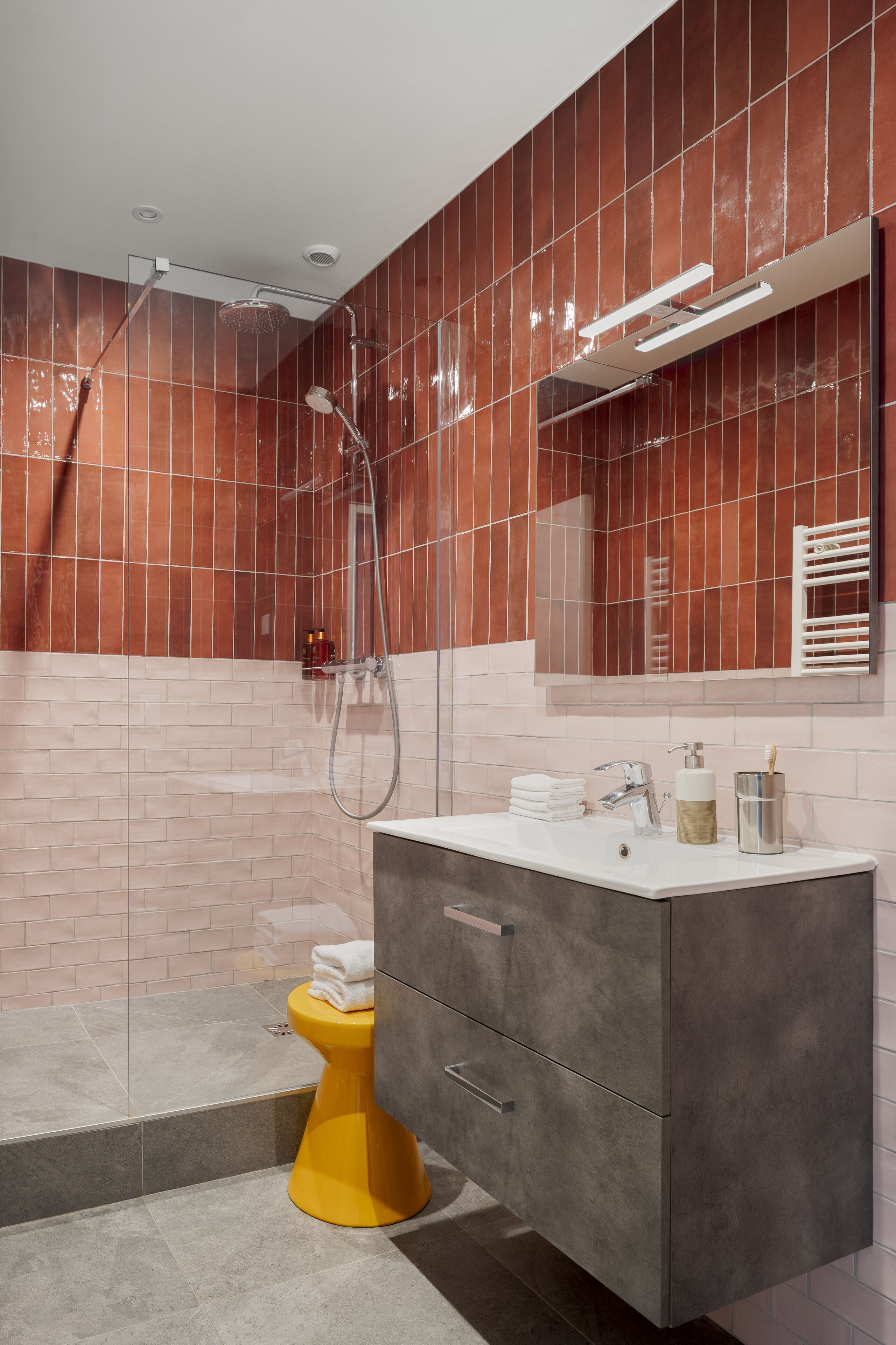 A modern bathroom with a shower, a toilet, and a vanity with a mirror.