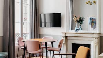 Una sala de estar moderna con chimenea, un televisor de pantalla plana y un comedor con sillas y mesa.