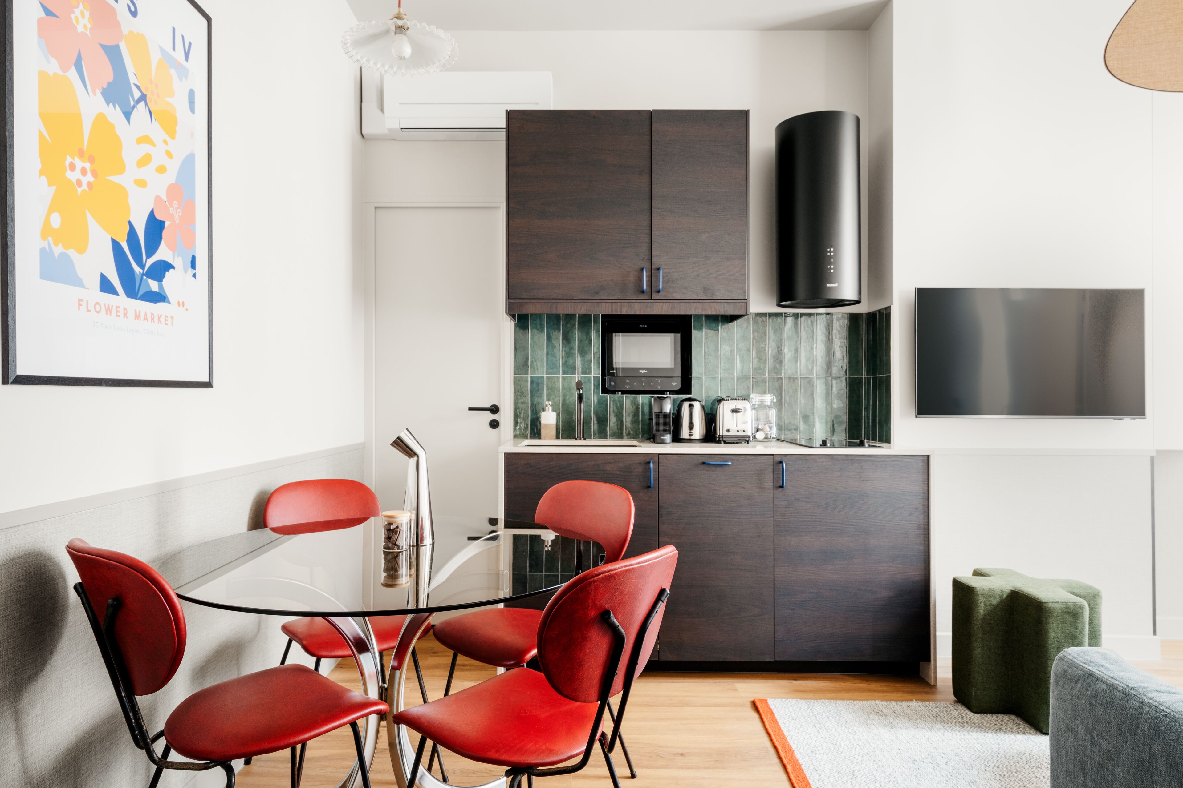 Une cuisine moderne avec des meubles en bois foncé, une hotte de cuisinière en acier inoxydable et un dosseret carrelé.