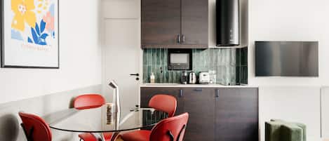 Une cuisine moderne avec des meubles en bois foncé, une hotte de cuisinière en acier inoxydable et un dosseret carrelé.