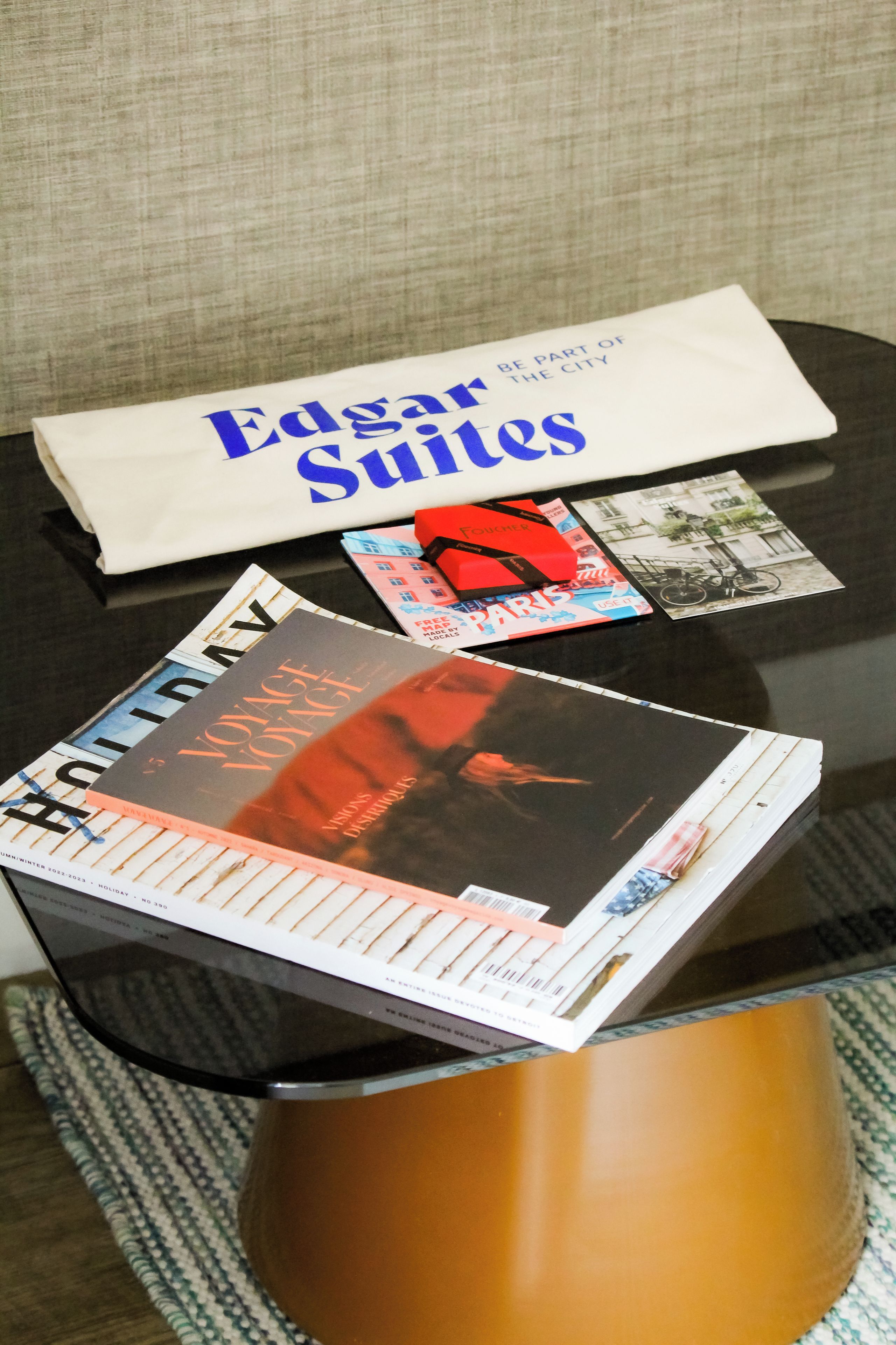 A table with a white envelope, a magazine, a postcard, and a book.
