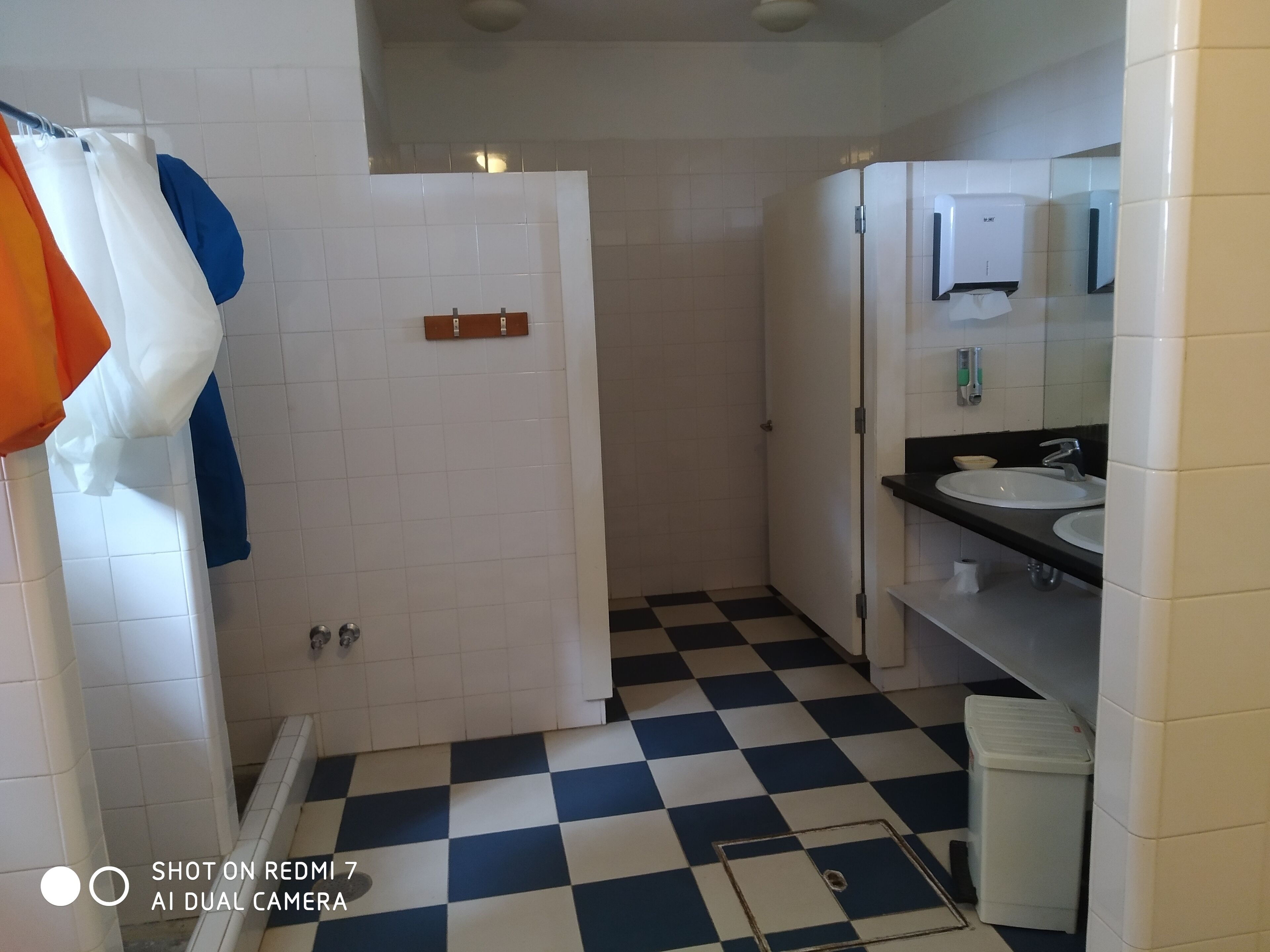 Een douche, een bidet, handdoeken, toiletpapier