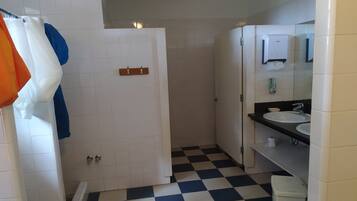 Une salle de bain avec un carrelage à motifs, des carreaux blancs, un lavabo et un miroir.