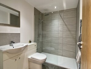 Enjoy a refreshing shower in the sleek bathroom with a glass-enclosed shower and standalone toilet.