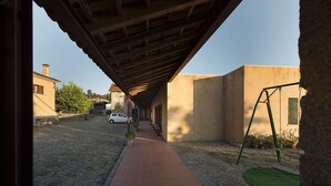Ein überdachter Außenweg, der zu einem Gebäude mit einer Schaukel führt.