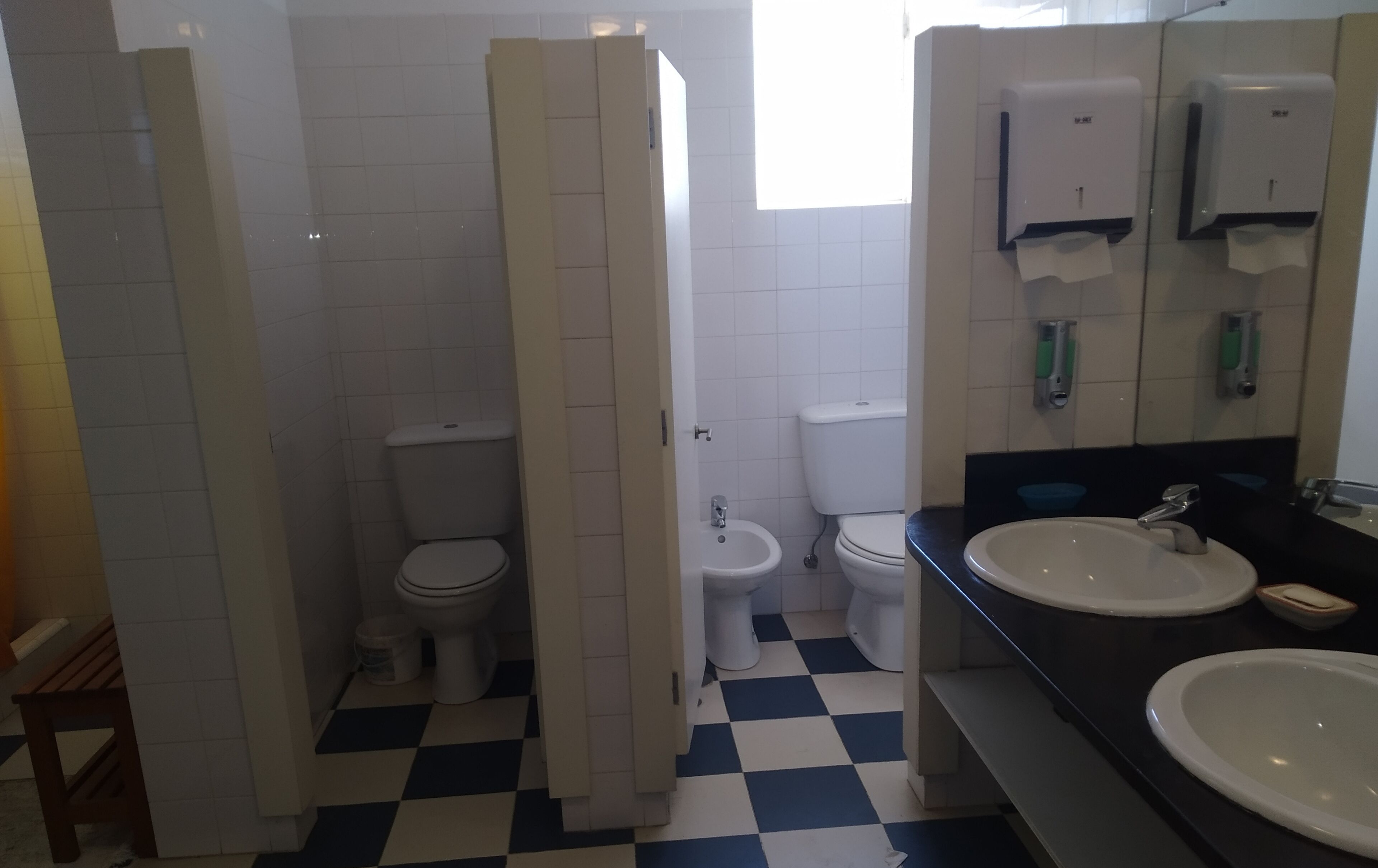 Un bagno con due servizi igienici, un lavandino e uno specchio.