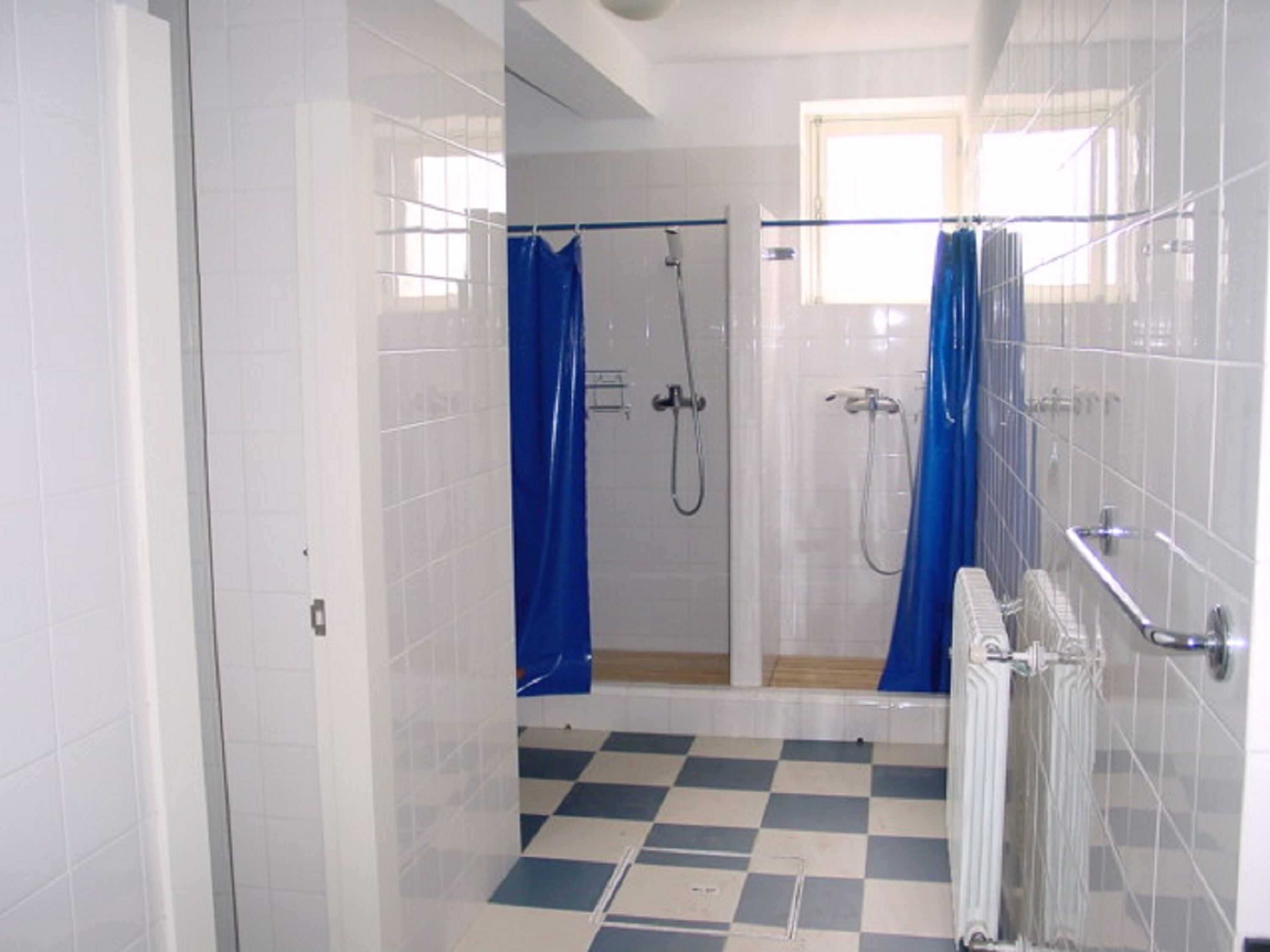 Een douche, een bidet, handdoeken, toiletpapier