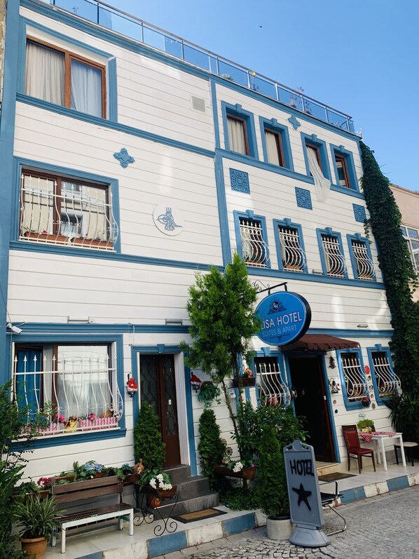 Een gebouw met twee verdiepingen, met een bord waarop staat: ISA HOTEL SUITES & APART.