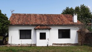 A white building with a tiled roof and two windows. - House in Galizano with garden (Cantabria)
