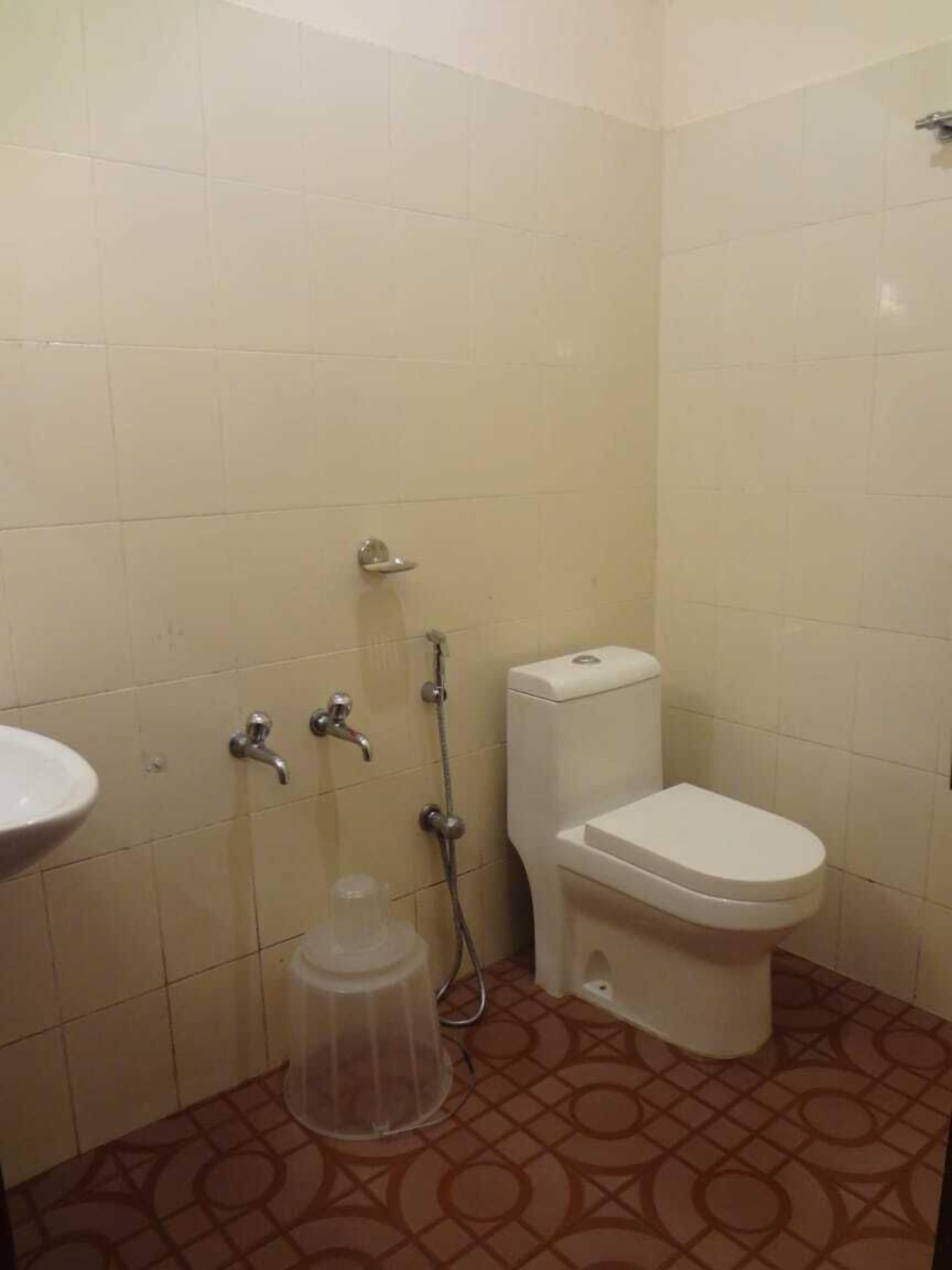 A small bathroom with a toilet, a sink, and a shower.
