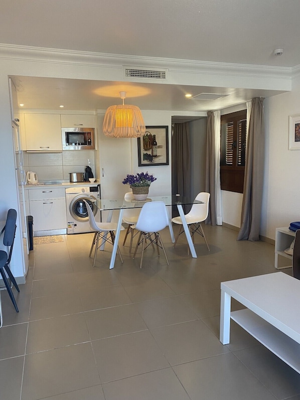 A modern apartment with a kitchen, dining area, and a living room.